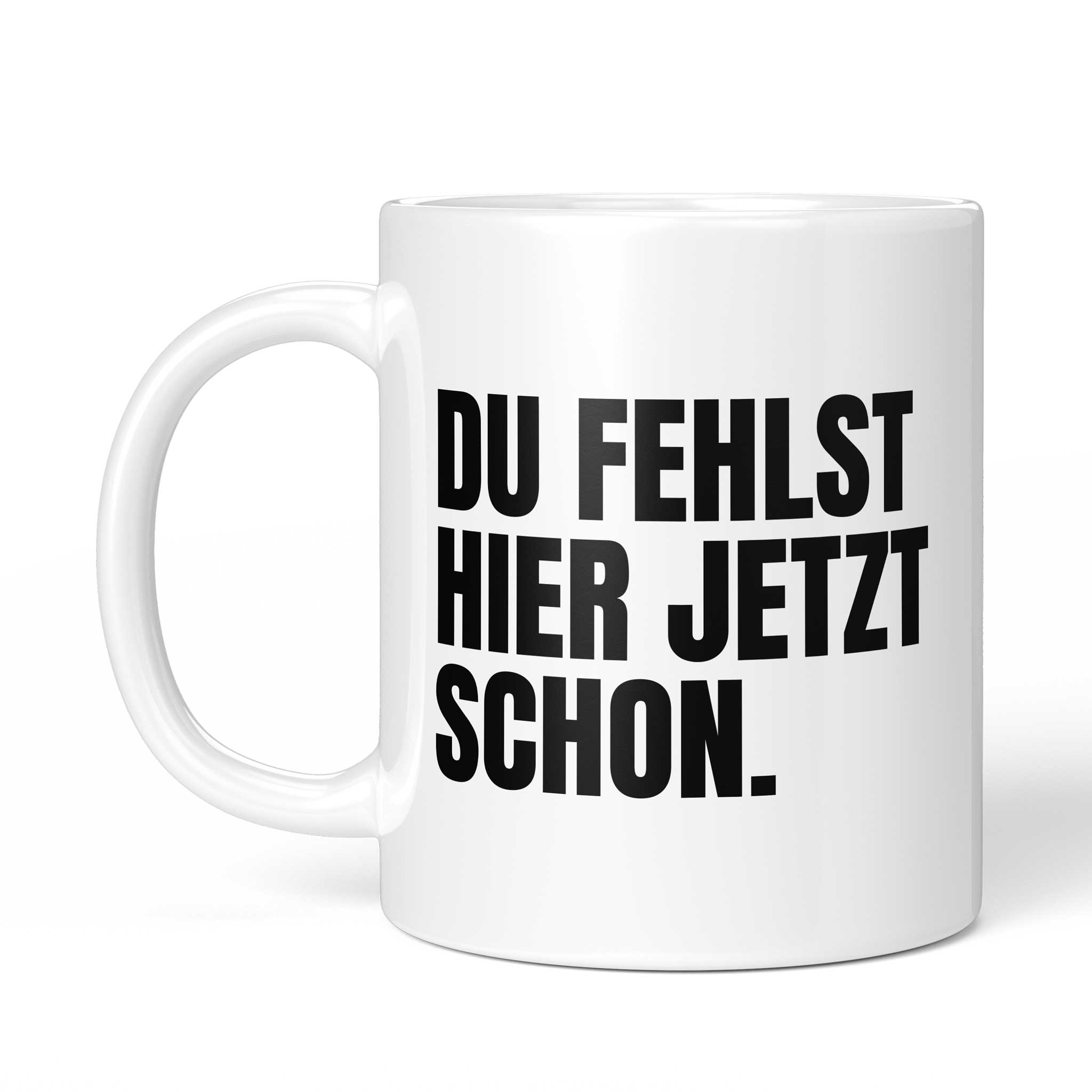 Tasse mit Spruch „DU FEHLST HIER JETZT SCHON.“ – Ansicht mit Henkel links