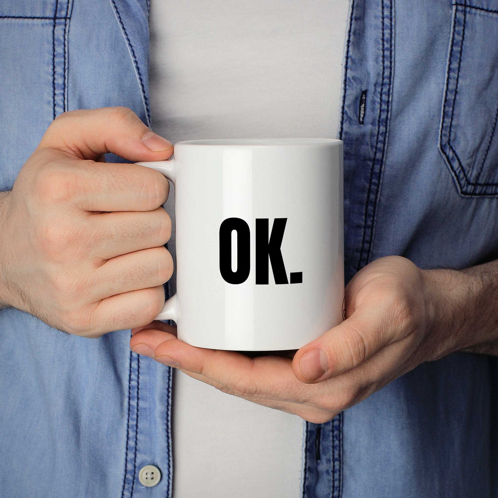 Brüllerware Statement-Tasse „OK.“ in der Hand gehalten – beidseitig bedruckte Kaffeetasse
