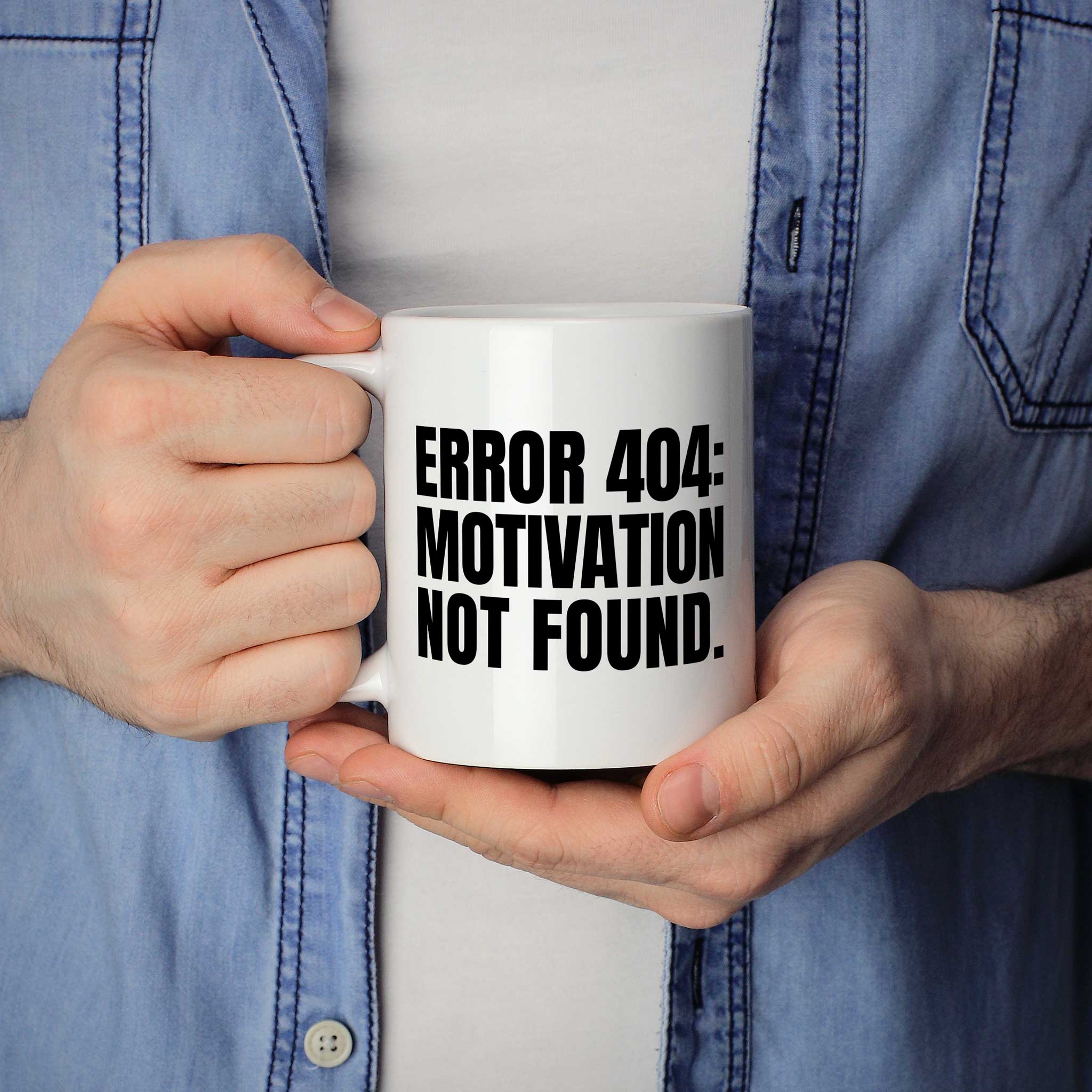 Brüllerware Statement-Tasse „ERROR 404: MOTIVATION NOT FOUND.“ in der Hand gehalten – beidseitig bedruckte Kaffeetasse