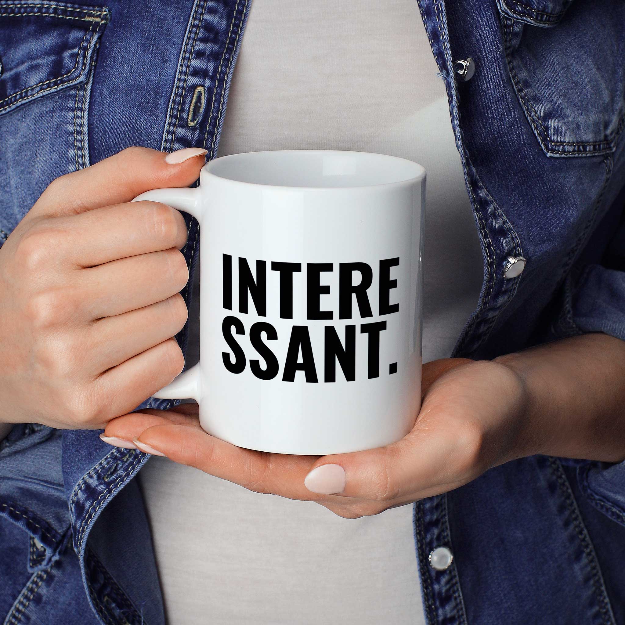 Brüllerware Statement-Tasse „Interessant“ in der Hand gehalten – beidseitig bedruckte Kaffeetasse
