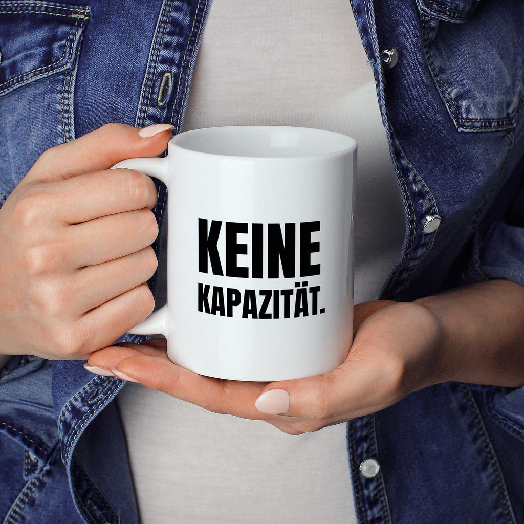Brüllerware Statement-Tasse „Keine Kapazität.“ in der Hand gehalten – beidseitig bedruckte Kaffeetasse
