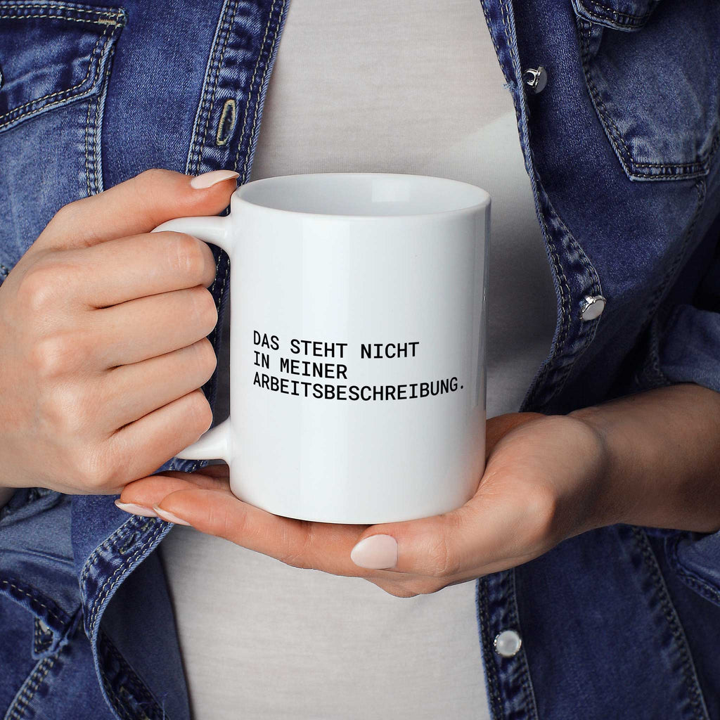 Brüllerware Statement-Tasse „Das steht nicht in meiner Arbeitsbeschreibung.“ in der Hand gehalten – beidseitig bedruckte Kaffeetasse