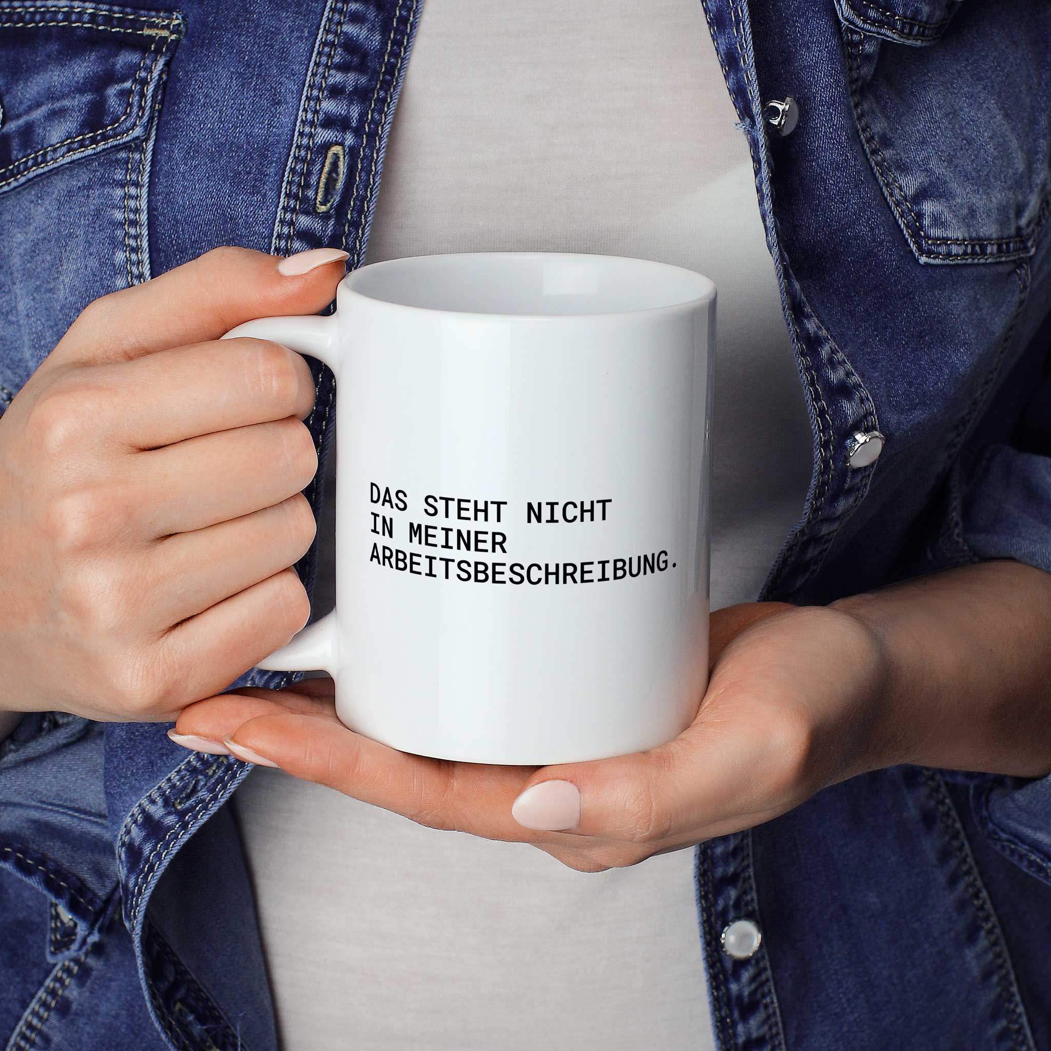 Brüllerware Statement-Tasse „Das steht nicht in meiner Arbeitsbeschreibung.“ in der Hand gehalten – beidseitig bedruckte Kaffeetasse