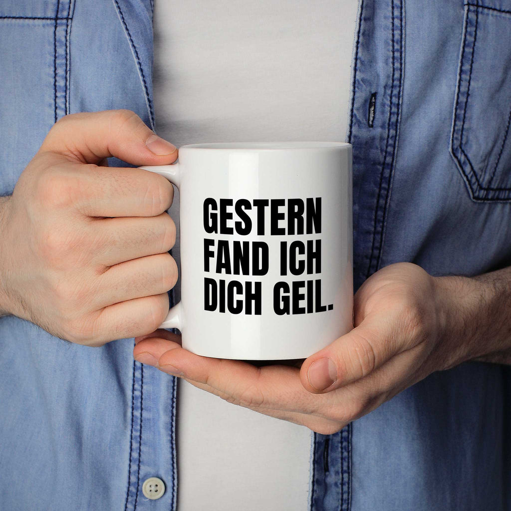 Brüllerware Statement-Tasse „Gestern fand ich dich geil.“ in der Hand gehalten – beidseitig bedruckte Kaffeetasse