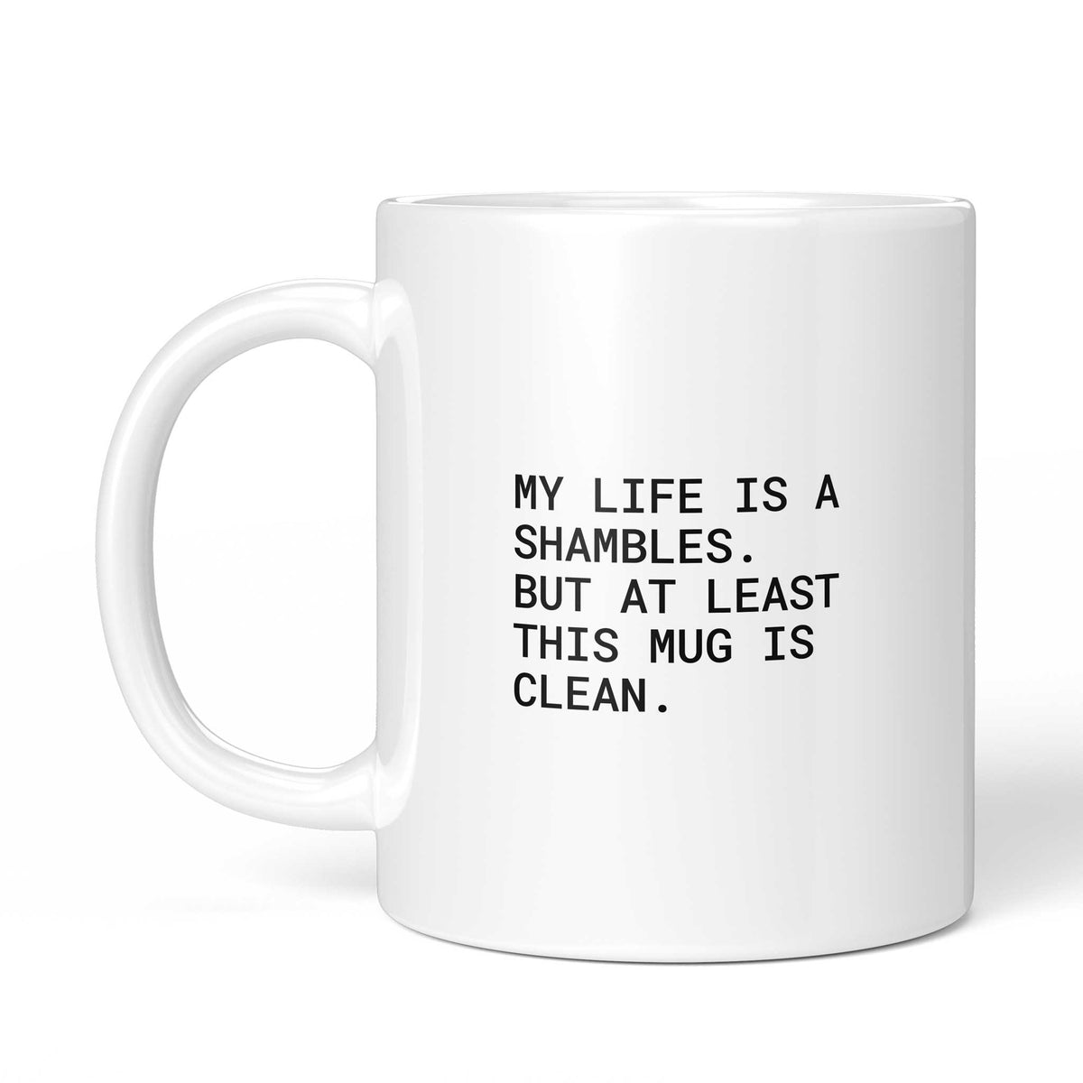 Weiße Tasse „At least this mug is clean“ mit Henkel links