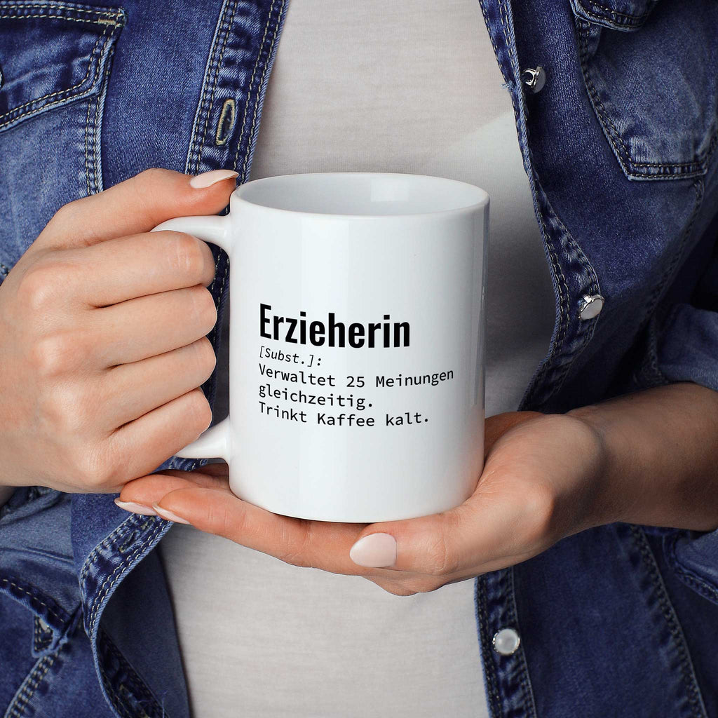 Frau hält lustige Tasse mit Spruch „Erzieherin: Verwaltet 25 Meinungen gleichzeitig. Trinkt Kaffee kalt." in beiden Händen – Größenvergleich, 330 ml Keramiktasse