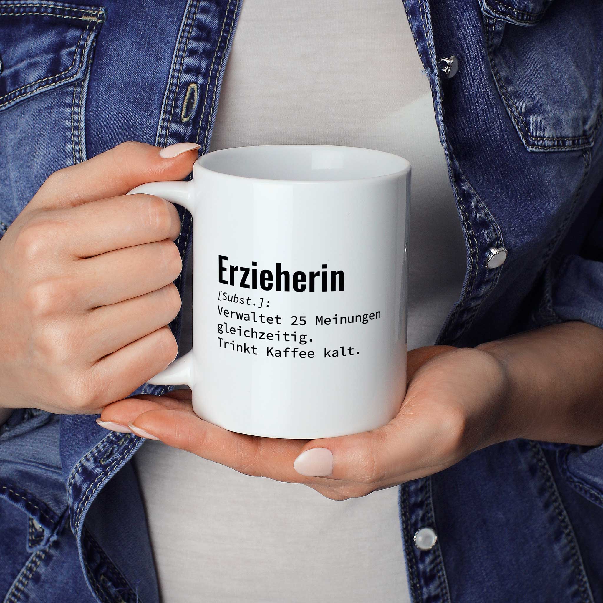 Frau hält lustige Tasse mit Spruch „Erzieherin: Verwaltet 25 Meinungen gleichzeitig. Trinkt Kaffee kalt." in beiden Händen – Größenvergleich, 330 ml Keramiktasse