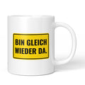 Lustige Tasse mit Spruch „Bin gleich wieder da." – weiße Keramiktasse mit schwarzem Druck, Vorderansicht