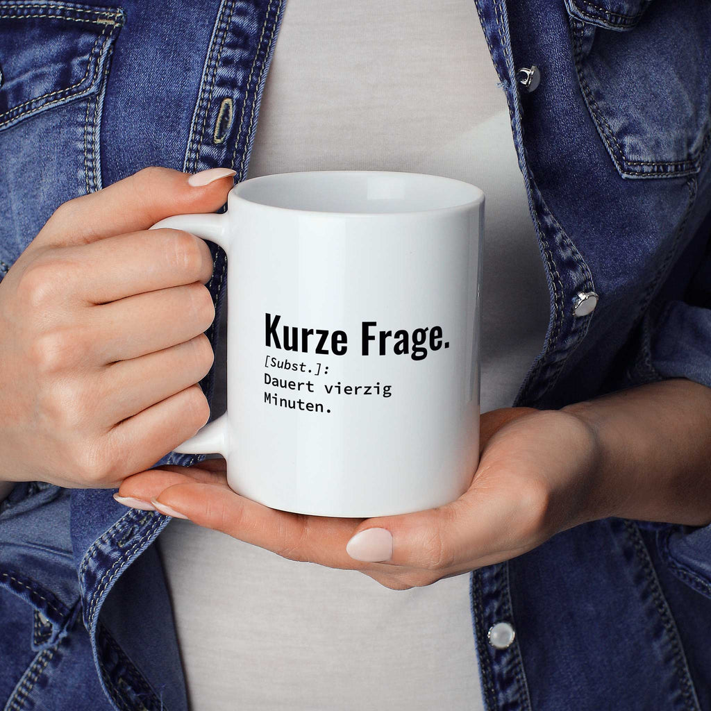 Frau hält lustige Tasse mit Spruch „Kurze Frage. Dauert vierzig Minuten." in beiden Händen – Größenvergleich, 330 ml Keramiktasse