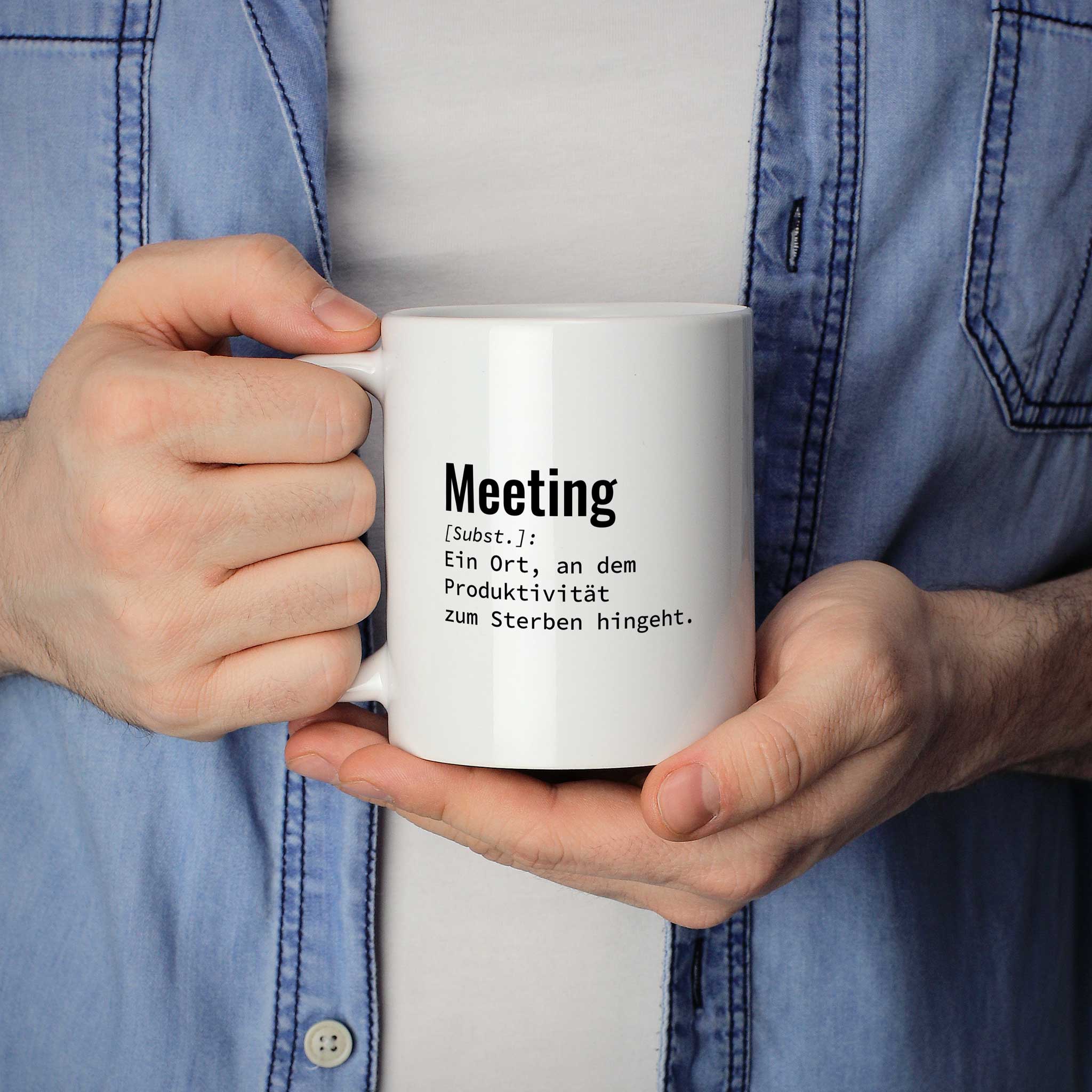 Mann hält lustige Tasse mit Spruch „Meeting: Ein Ort, an dem Produktivität zum Sterben hingeht." in beiden Händen – Größenvergleich, 330 ml Keramiktasse