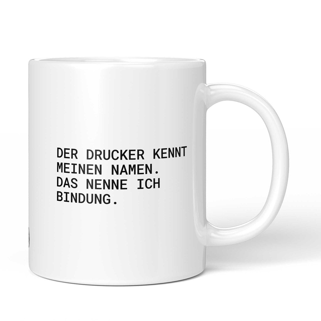 Weiße Tasse mit Spruch „Der Drucker kennt meinen Namen. Das nenne ich Bindung.“ – Brüllerware