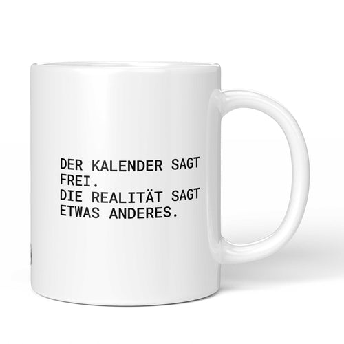 Weiße Tasse mit Spruch „Der Kalender sagt frei, die Realität sagt etwas anderes.“ – Brüllerware