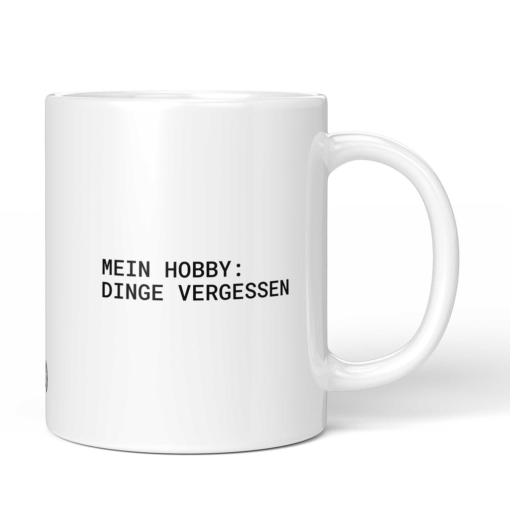 Brüllerware Tasse mit Spruch „Mein Hobby: Dinge vergessen“ – weiße Keramiktasse mit schwarzem Statement-Druck und Brüllerware Icon