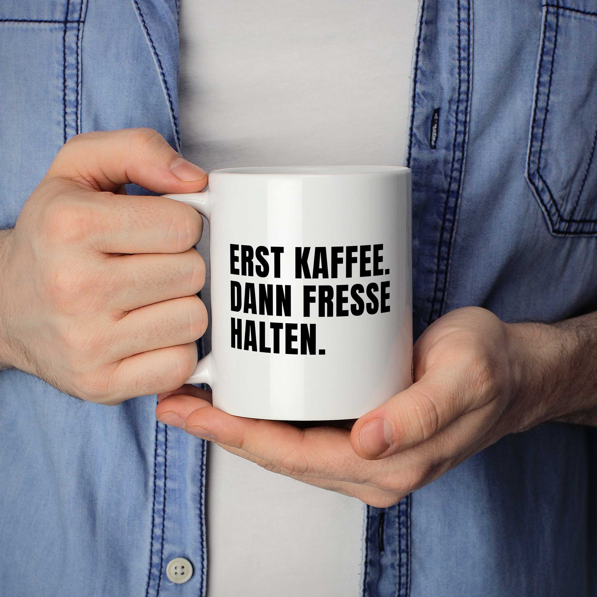 Lustige Tasse "Erst Kaffee. Dann Fresse halten." als Geschenkidee - Brüllerware Statement Becher in der Hand