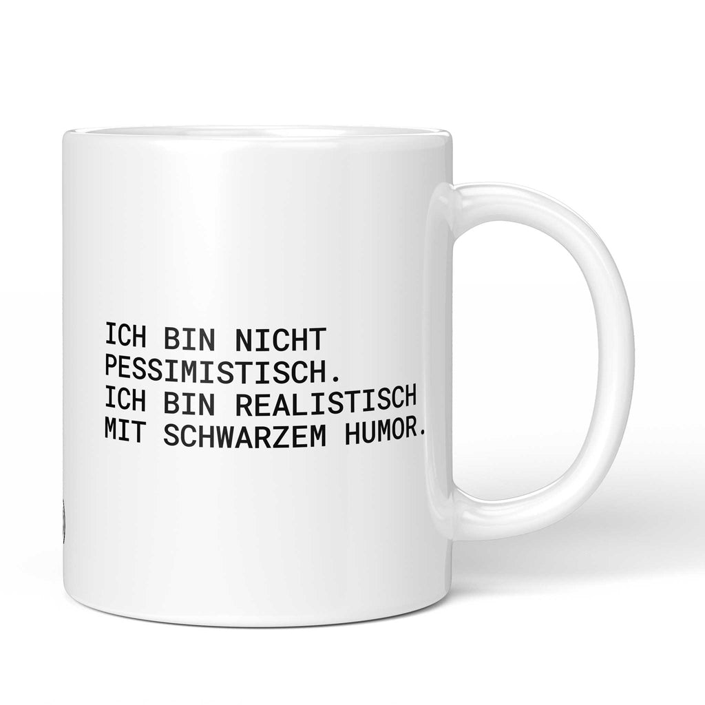 Weiße Tasse mit Spruch „Ich bin nicht pessimistisch – ich bin realistisch mit schwarzem Humor.“ – Brüllerware