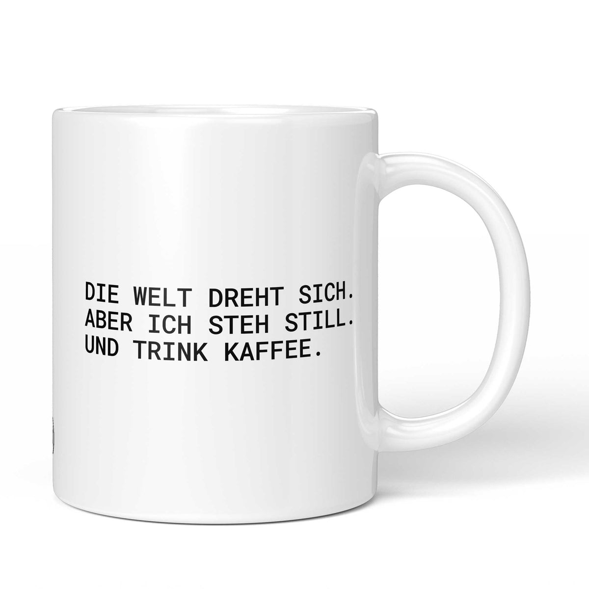 Weiße Tasse mit Spruch „Die Welt dreht sich – aber ich steh still. Und trink Kaffee.“ – Brüllerware