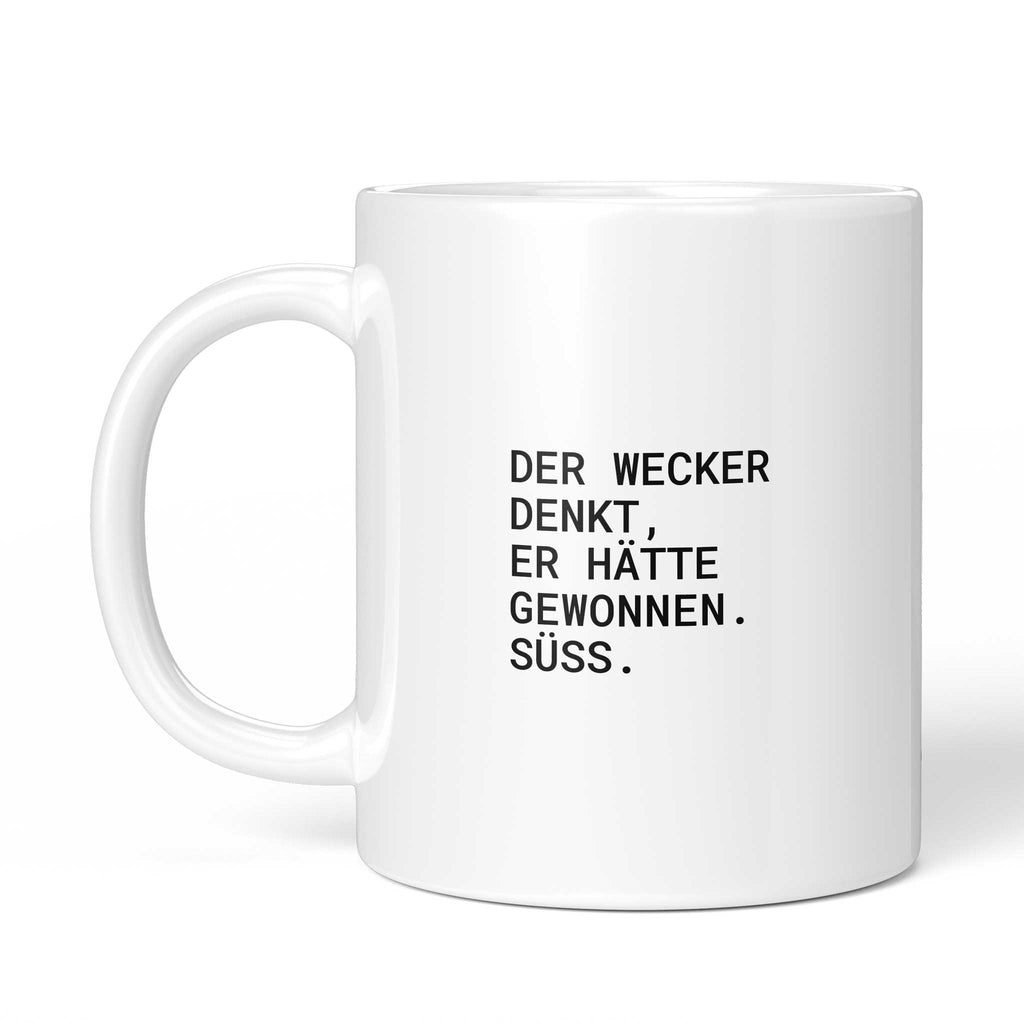Weiße Tasse „Der Wecker denkt, er hätte gewonnen. Süß.“ mit Henkel links