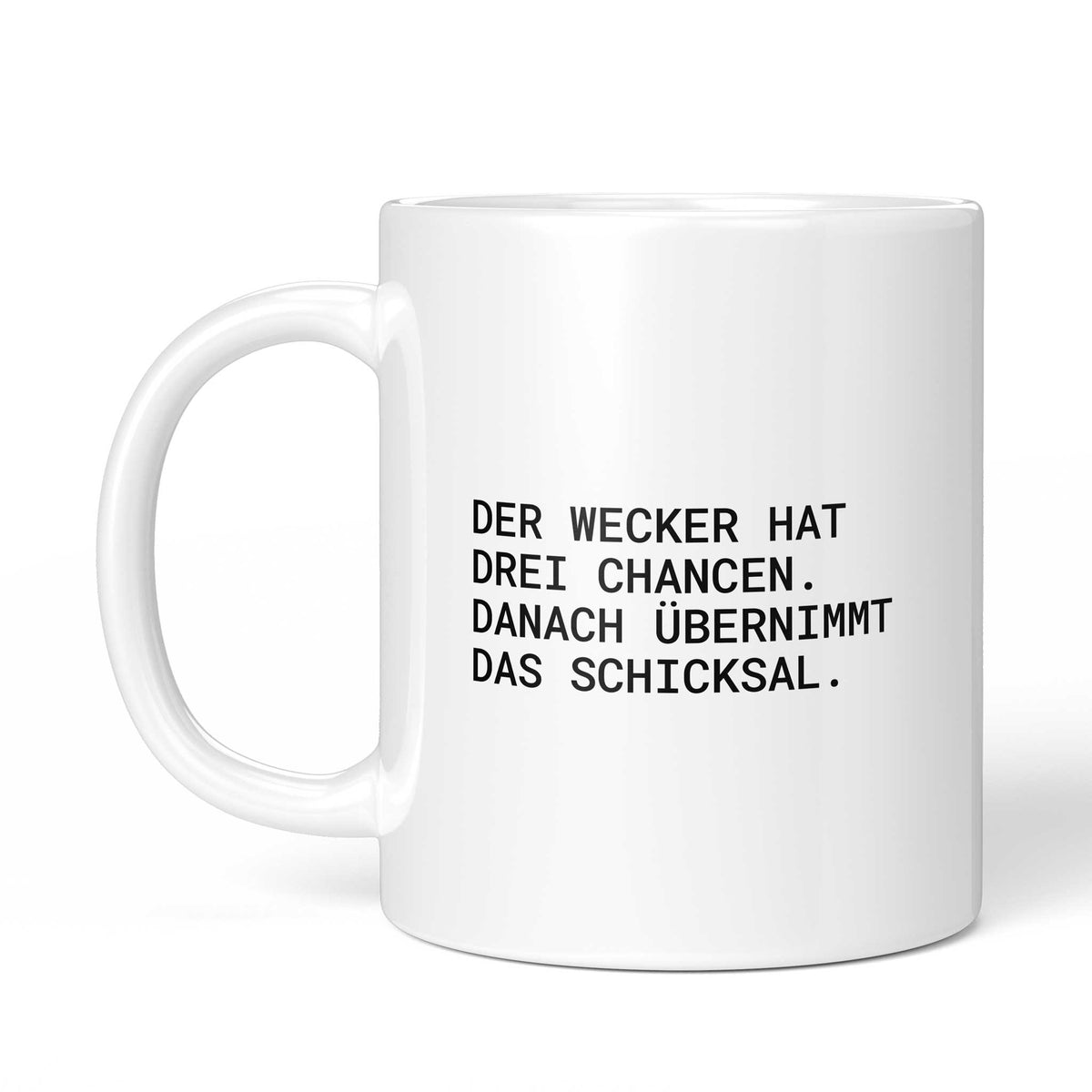 Weiße Tasse „Der Wecker hat drei Chancen“ mit Henkel links